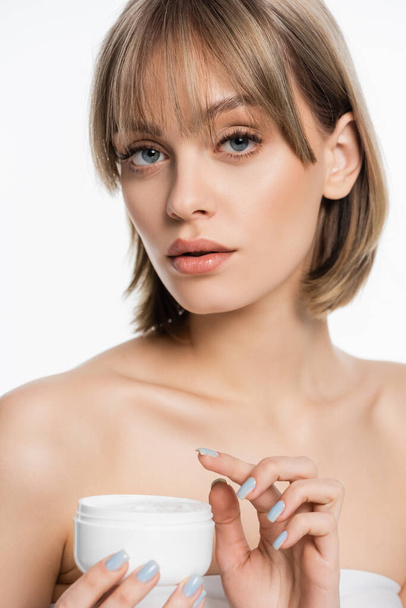 young woman with bangs holding container with face cream isolated on white  - Φωτογραφία, εικόνα