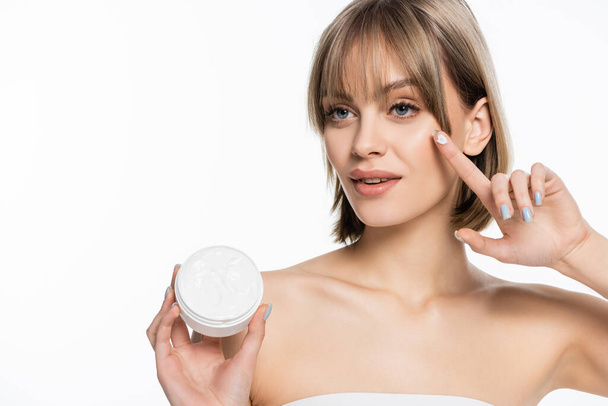 pretty young woman with bangs holding container with face cream isolated on white  - Fotó, kép