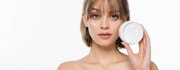 young woman with bangs and cream on face holding container isolated on white, banner - Foto, immagini