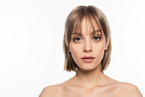 young woman with bangs hairstyle and bare shoulders looking at camera isolated on white - Photo, Image