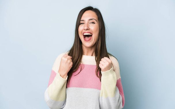 young adult pretty woman shouting triumphantly, laughing and feeling happy and excited while celebrating success - Photo, Image