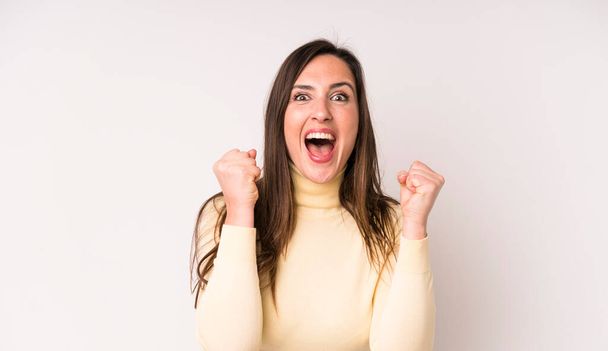young adult pretty woman feeling shocked, excited and happy, laughing and celebrating success, saying wow! - Photo, image