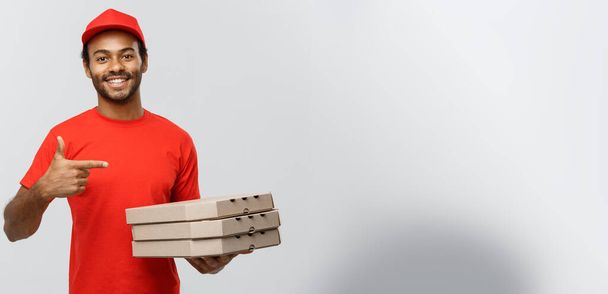 Szállítás fogalma - boldog afro-amerikai szállítási portréja ember kéz bemutatni pizza doboz csomagok. Elszigetelt szürke stúdió háttér. Másolja a hely. - Fotó, kép