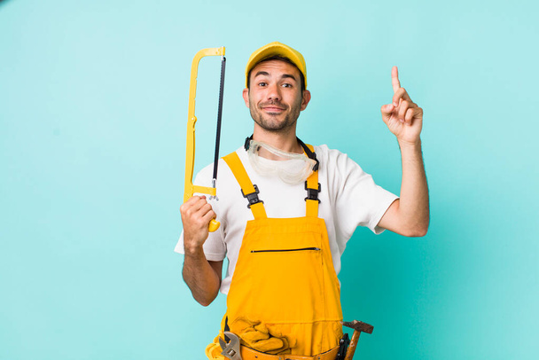 young adult man. handyman with a saw concept - Foto, afbeelding
