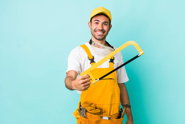 young adult man. handyman with a saw concept - Photo, Image