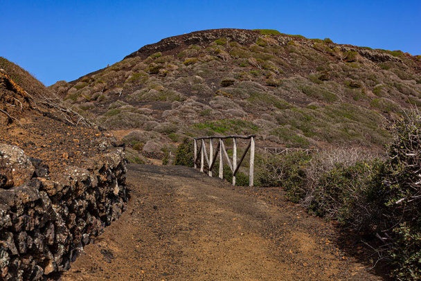 Путь к вулкану Монте-Неро в Линозе. Характерная сельская дорога с каменной стеной из лавы - Фото, изображение