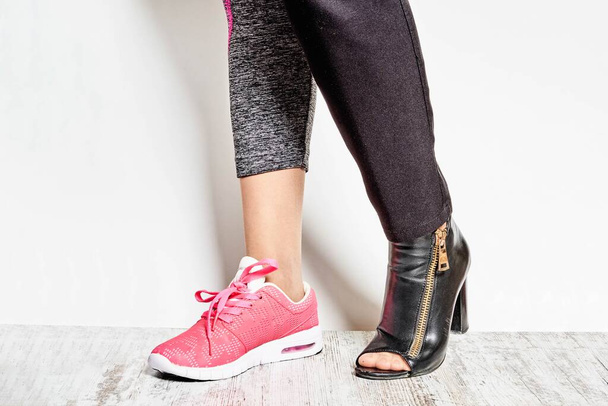 Female wearing official high-hilled shoe and sneaker - Foto, Imagem