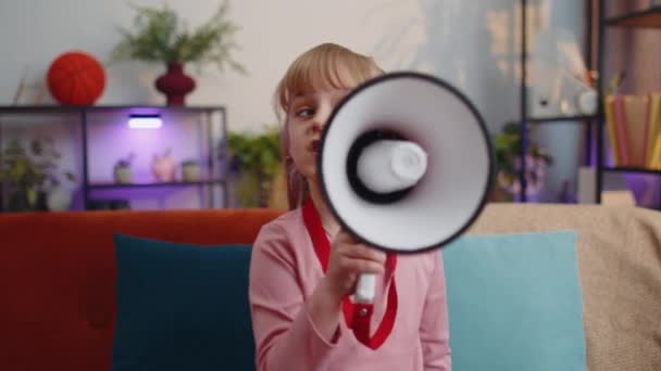 Criança menina garoto de pé no sofá em casa sozinho em voz alta gritar em megafone anuncia descontos venda - Filmagem, Vídeo