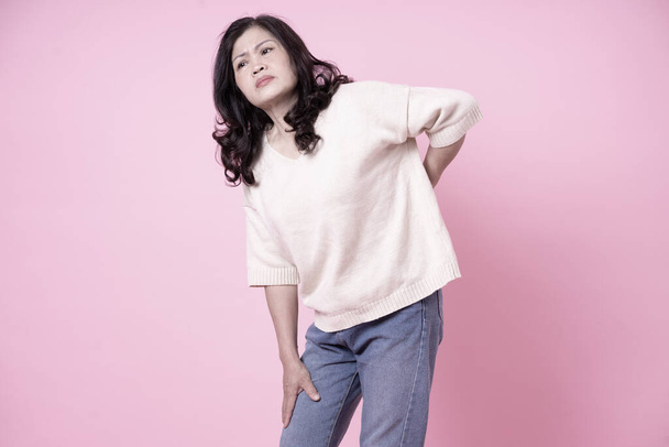 Imagem da mulher asiática de meia idade no fundo rosa - Foto, Imagem