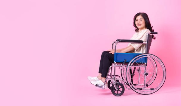 Image of middle aged Asian woman on pink background - Фото, изображение