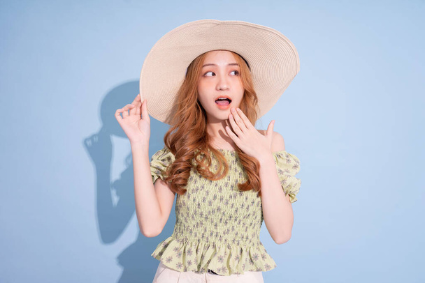 Portrait of young Asian girl wearing hat on blue background - Photo, Image