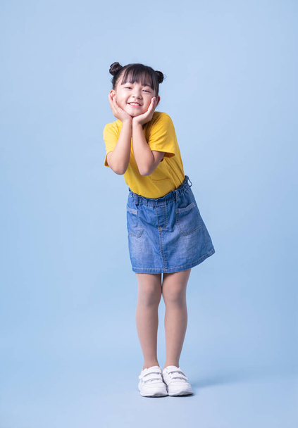 Imagen de niño asiático posando sobre fondo azul - Foto, imagen
