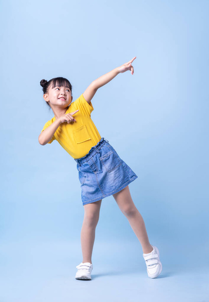 Imagen de niño asiático posando sobre fondo azul - Foto, imagen