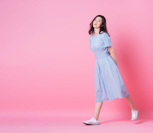 Full length image of young Asian woman wearing blue dress on pink background - Fotoğraf, Görsel