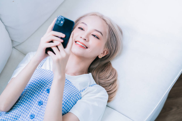 Young Asian girl using smartphone at home - Foto, immagini