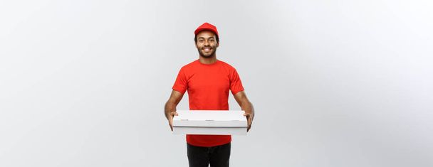 Delivery Concept - Portré jóképű afro-amerikai pizzafutár. Elszigetelve a szürke stúdió hátterében. Fénymásolási tér. - Fotó, kép