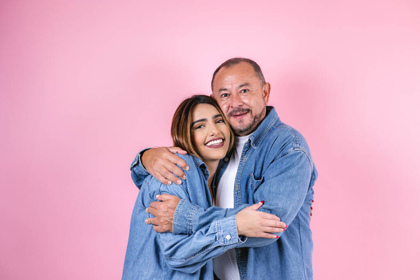 padre e hija latinos en ropa casual en un espacio de copia sobre fondo rosa en México América Latina - Foto, imagen