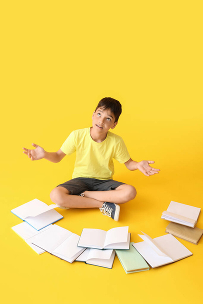 Little boy with open books on yellow background - Φωτογραφία, εικόνα