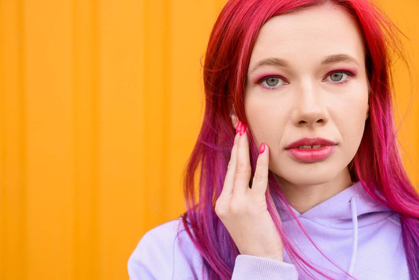 Young woman with bright hair on yellow background, closeup - Foto, Imagem