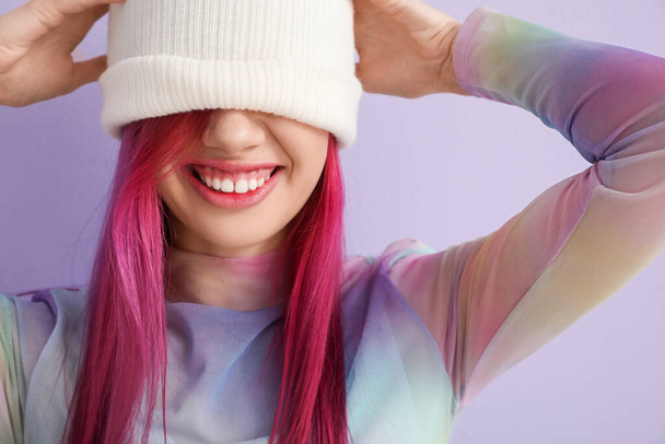 Beautiful young woman with bright hair on lilac background, closeup - 写真・画像