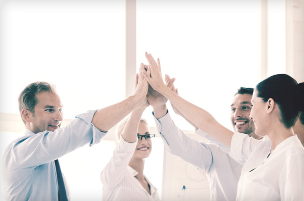 happy business team giving high five in office - Photo, Image