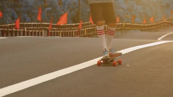 Portrecista z longboardem na pięknej drodze. Teenager skateboarding na ulicach miasta - Materiał filmowy, wideo