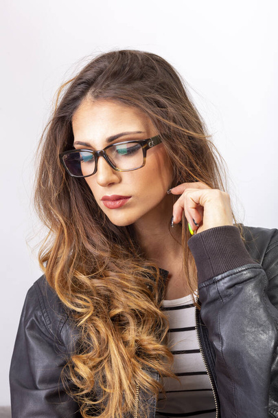 beautiful brunette italian girl posing in studio with eyeglasses. High quality photo - Foto, Imagen