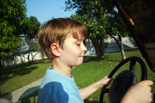 Çocuk eski bir eski bir sarayda bir elektrikli araba sürmeyi seviyor. - Fotoğraf, Görsel