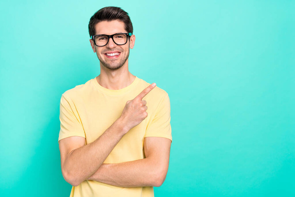 Photo of funny brunet young guy index promo wear eyewear yellow t-shirt isolated on turquoise color background - Foto, Imagem