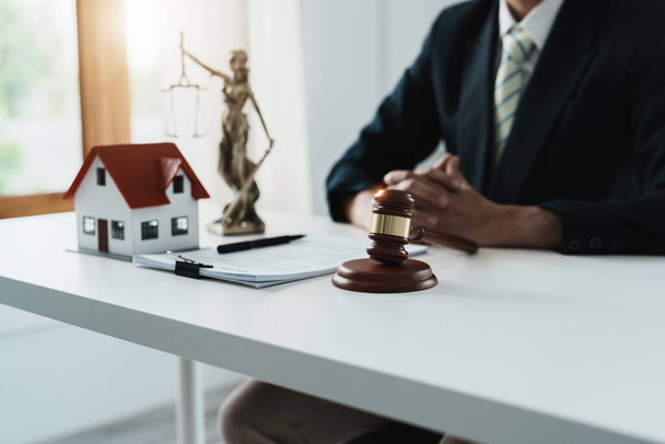 Law, Consultation, Agreement, Contract, Concept Attorney or lawyer focusing on the court hammer is sitting on the chair with a clients complaint to determine the house and land in court - Foto, imagen