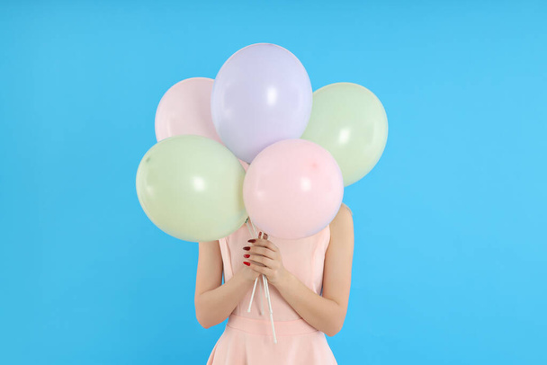 Concept of Happy Birthday, young woman with balloons on blue background - Photo, image