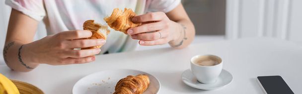 partial view of woman holding delicious croissant near coffee cup, banner - Foto, Imagem