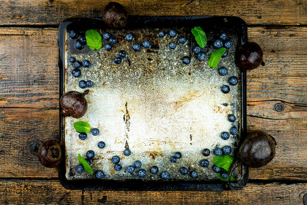 Tray with blueberries,beads and mint leaves with emty space in the middle on a rustic wooden table. Green, detox, healthy diet concept. Copy space, add text. Top view, flat lay photo - Photo, Image
