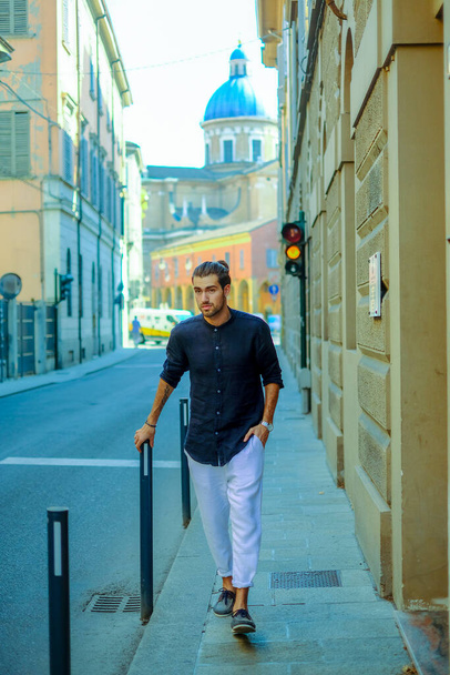 Yakışıklı, siyah saçlı İtalyan çocuk şehir merkezinde yürüyor. Yüksek kalite fotoğraf - Fotoğraf, Görsel