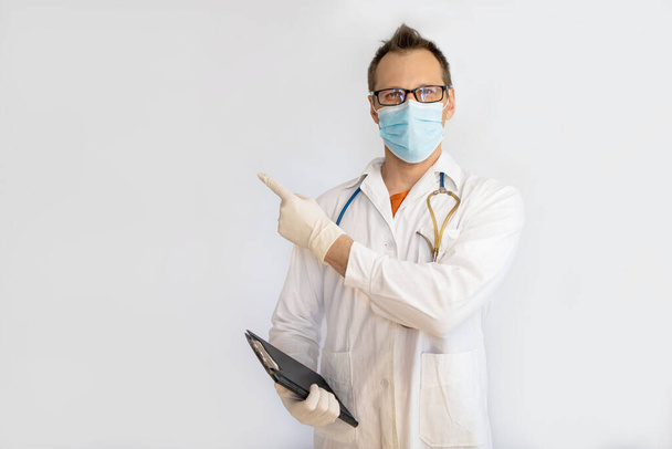 Middle aged man doctor, medical professional holding something in empty hand, isolated on white background - Photo, Image