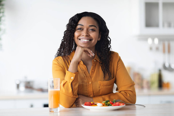 Feliz joven mujer negra desayunando adecuadamente, cocina interior - Foto, Imagen