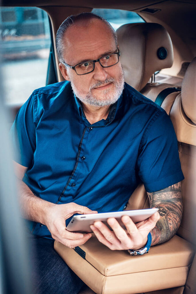 Homme d'affaires âgé avec tablette à l'intérieur de la voiture à l'extérieur - Photo, image