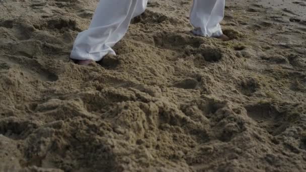 Bare man legs standing beach in karate pose closeup. Athlete workout martial art - Materiaali, video