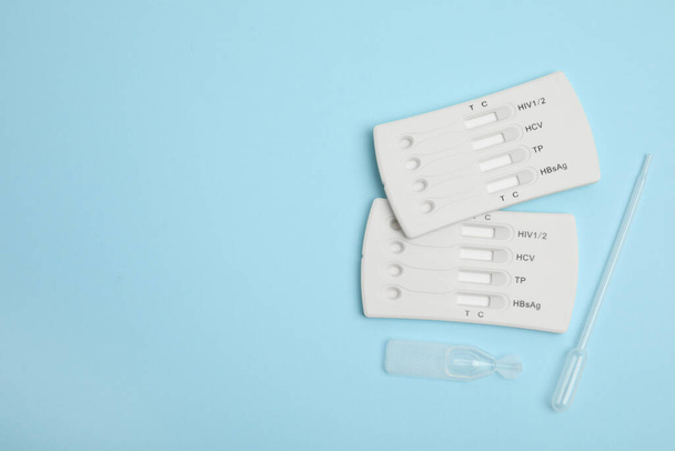 Disposable express hepatitis test kit on light blue background, flat lay. Space for text - Foto, Bild