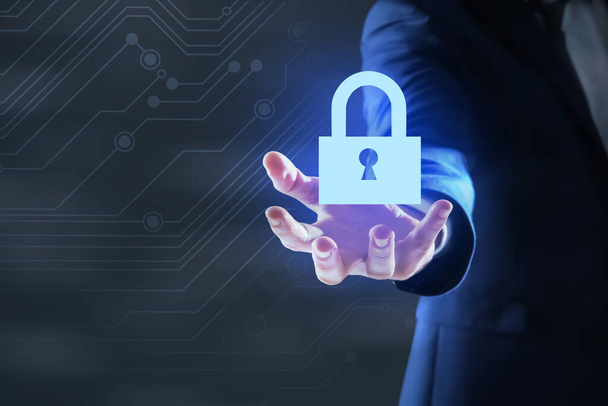 Cyber security concept. Man holding virtual icon of padlock on dark background, closeup - Фото, зображення