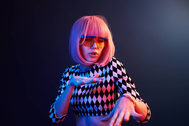 Portrait of young girl with blond hair in eyeglasses in red and blue neon in studio. - Photo, Image