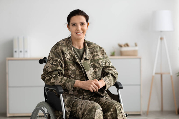 Programas de reabilitação para veteranos. Retrato de mulher militar feliz sentada em cadeira de rodas - Foto, Imagem