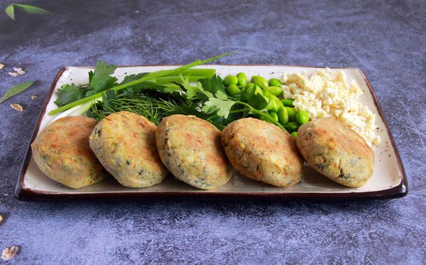 Vegan savory syrnyky made of tofu with different herbs. Salt cheesecakes for breakfast with soy cheese and dill, parsley and green onions. - 写真・画像