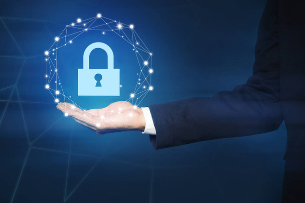 Cyber security concept. Man holding virtual icon of padlock on dark background, closeup - Zdjęcie, obraz