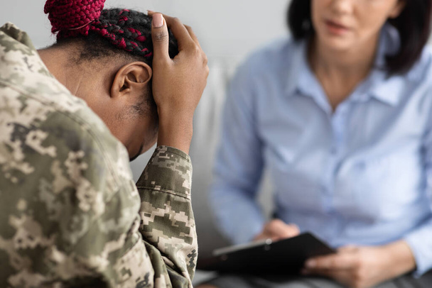 Ψυχικές διαταραχές στο Στρατιωτικό Προσωπικό. Θλιβερή γυναίκα στρατιώτης κατά τη διάρκεια της συνάντησης με ψυχοθεραπευτή - Φωτογραφία, εικόνα