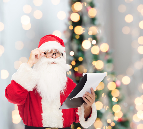 man in costume of santa claus with notepad - Foto, Imagen