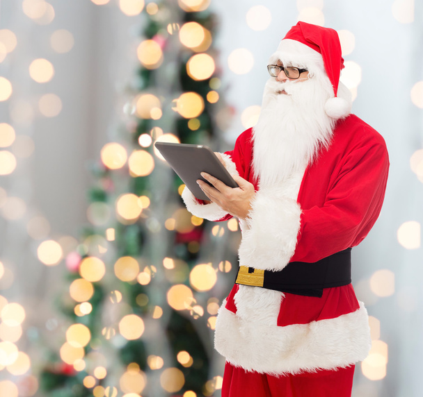 man in costume of santa claus with tablet pc - 写真・画像