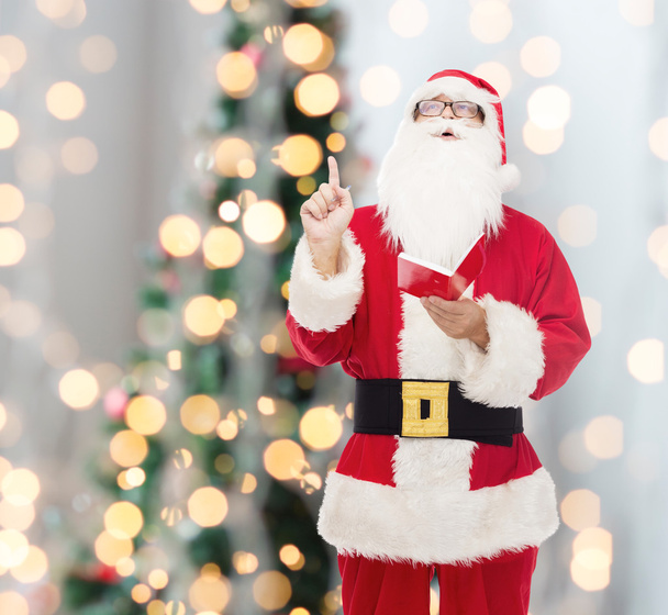 man in costume of santa claus with notepad - Foto, Bild