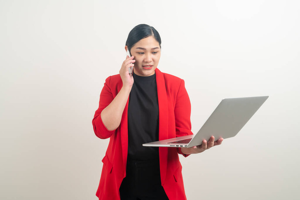 Asijské obchodní žena mluví telefon s rukou drží notebook na bílém pozadí - Fotografie, Obrázek