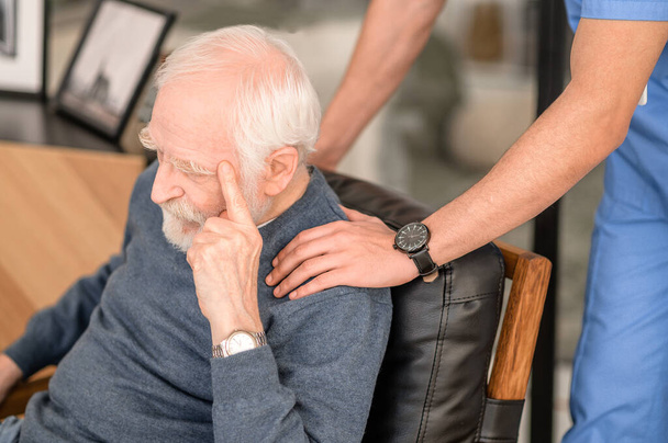 Experienced male nurse comforting an elderly person - Fotoğraf, Görsel